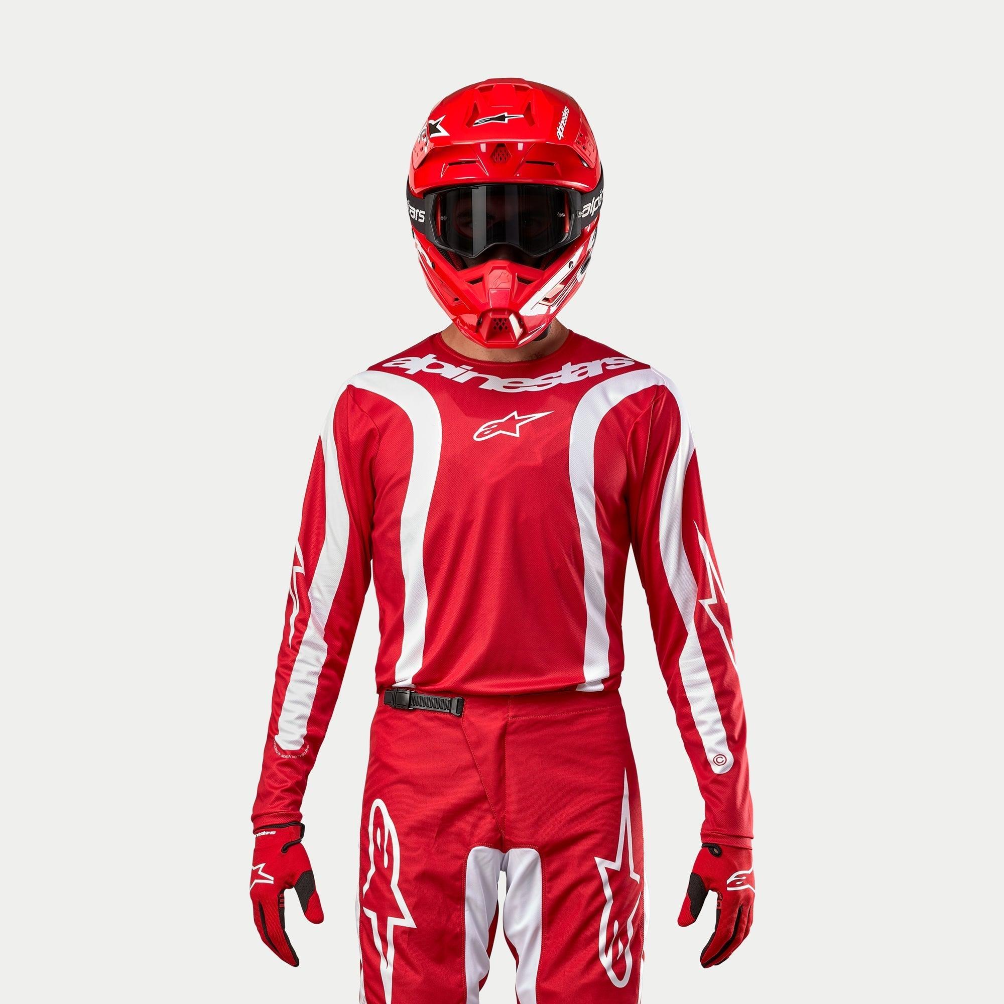 Camisola Alpinestars 2024 Fluid Lurv, camisola de motocross, Vermelho Mars e branco, usada com calças, capacete e luvas vermelhas a condizer, com detalhes gráficos brancos nas mangas e marca em destaque no peito, corte atlético para corridas todo-o-terreno