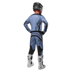 Piloto de motocross visto de costas a usar a camisola Alpinestars 2024 Fluid Lurv e calças a condizer em azul claro e preto, com logótipos pretos nas costas e mangas, acompanhado por capacete preto e botas brancas