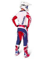 Motocross rider seen from the back wearing the Alpinestars Limited Edition Techstar Fortitude Jersey and Gear Set, Bright Red White and Blue colorway, featuring white Alpinestars branding on red sleeves and a navy logo on the white back, paired with a white motocross helmet and matching racing boots.