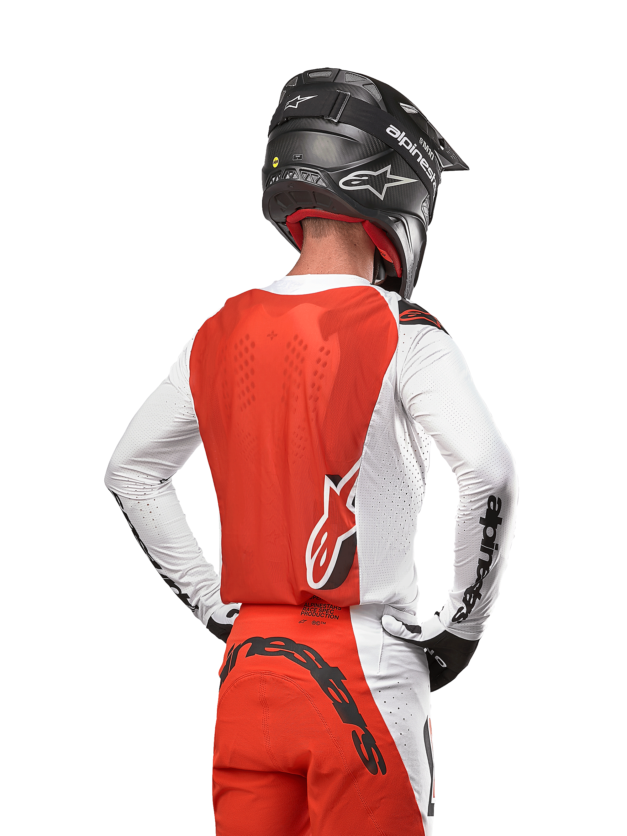 Camisola Alpinestars Supertech Ward 2024 em White Hot Orange, vista traseira de um piloto de motocross, painel traseiro laranja e mangas brancas com logótipo preto, calças a condizer e capacete preto, equipamento profissional para off-road
