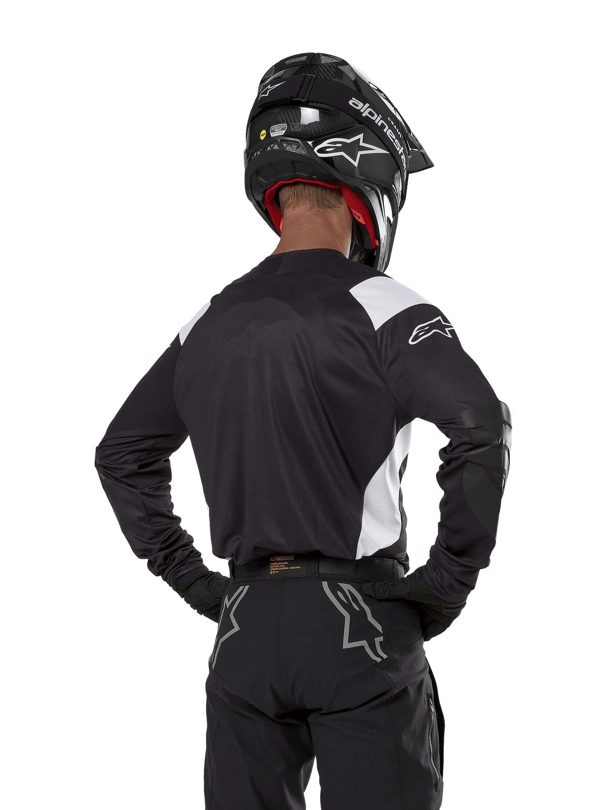 Alpinestars Techdura Jersey, Black with white shoulder accents, back view of motocross rider wearing matching black pants and helmet, reinforced elbow patches, enduro and off-road racing gear