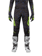 Alpinestars 2024 Techstar Rantera Pants, Motocross Pants, Black Navy and Yellow Fluo, worn with matching long-sleeve jersey, gloves and white motocross boots, featuring bold neon yellow accents and abstract dark pattern.