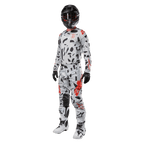 Piloto de motocross com camisola Alpinestars 2024 Techstar Rantera em Haze Gray Camo, calças a condizer com detalhes em vermelho e preto, capacete e óculos pretos, luvas pretas, botas brancas e pretas, equipamento completo de motocross para performance todo-o-terreno