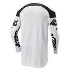 Alpinestars 2024 Racer Hana Jersey, camisola de motocross, branca e preta, vista traseira com corte mais longo para maior cobertura, painéis pretos nos ombros e logótipos manuscritos pretos nas mangas, tecido durável que absorve a humidade para desempenho off-road