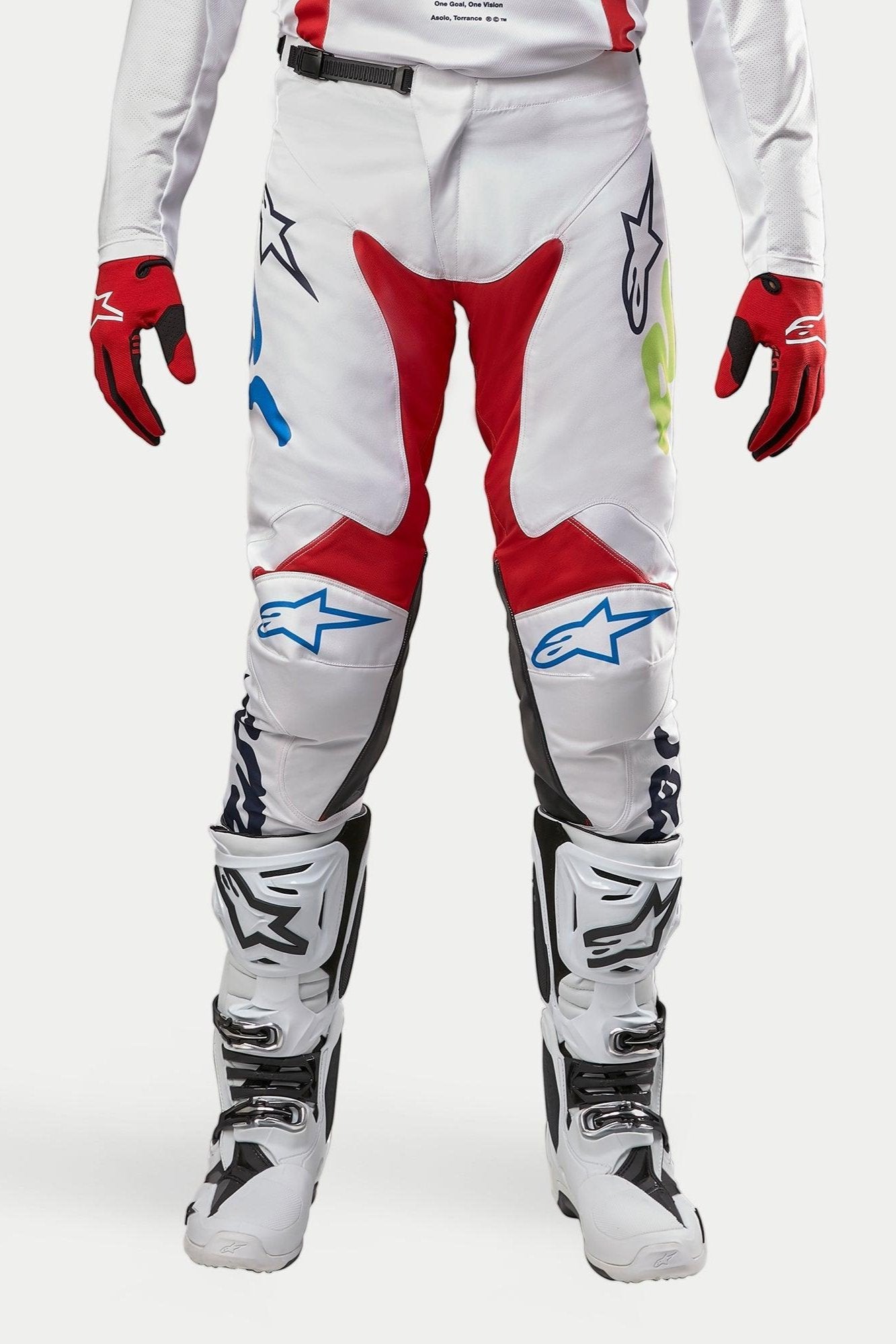 Alpinestars 2024 Racer Hana Pants, Motocross Pants, White Multicolor with red, blue, and lime accents, worn with white and black boots and red gloves, featuring Alpinestars logos on the knees and a durable technical design for off-road racing