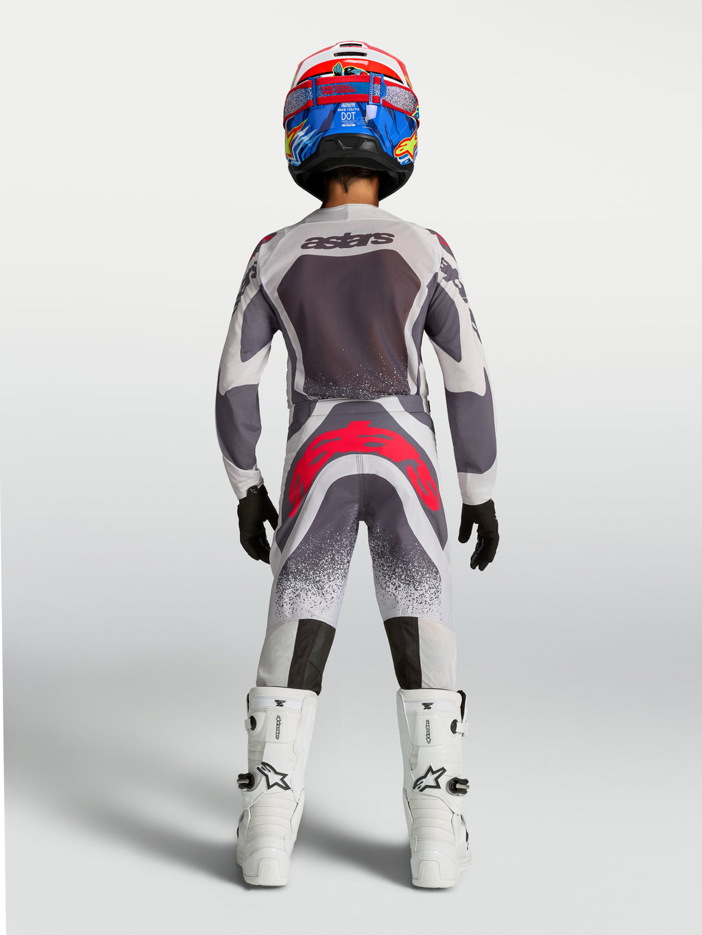 Alpinestars Juventude Supertech Swan 2027, camisola e conjunto de motocross cinzento, branco e vermelho, vista traseira.