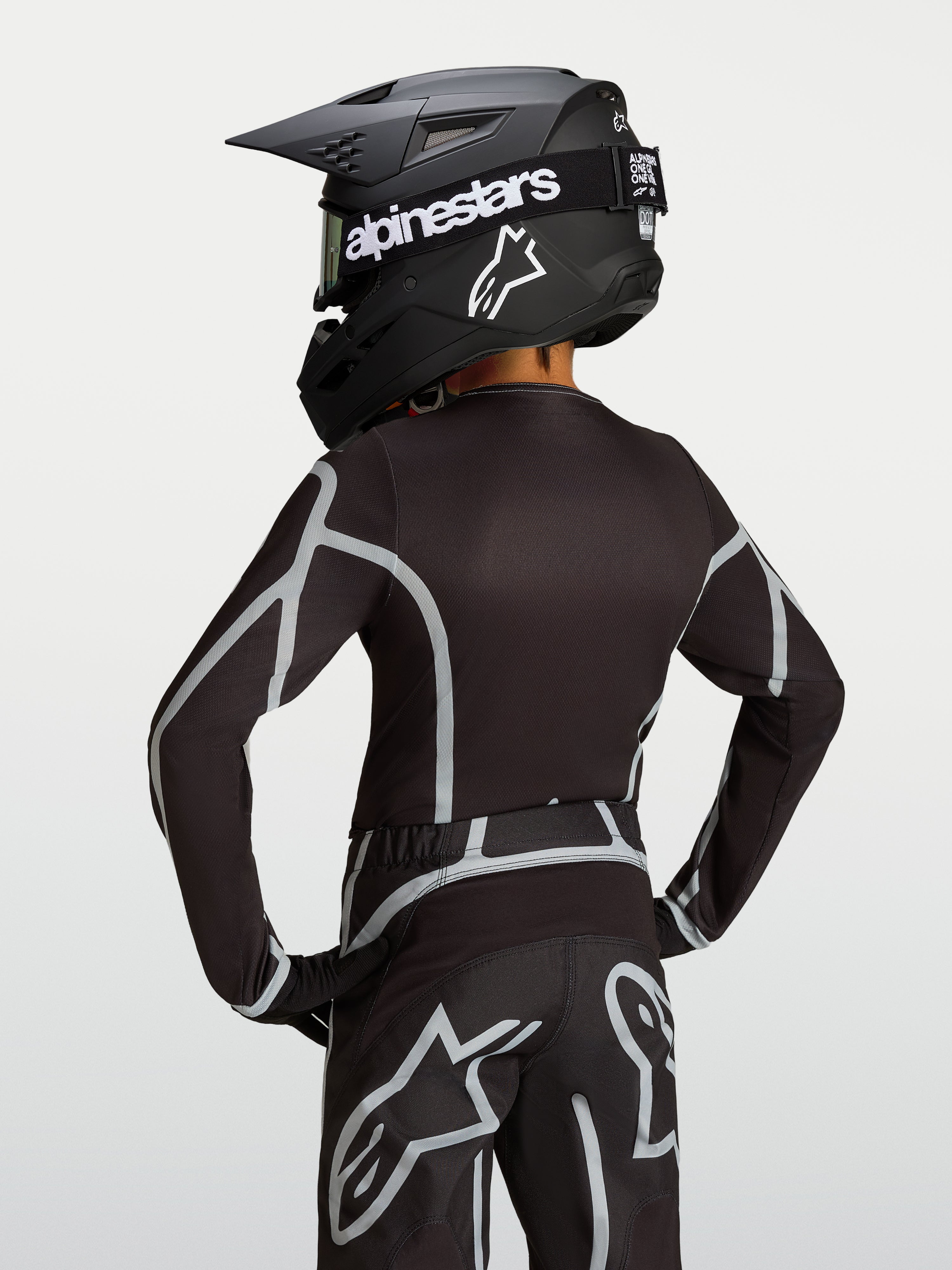 Alpinestars camisola Fluid Apex V2 Jovem, preta e prateada, vista traseira de equipamento de motocross com corte atlético.