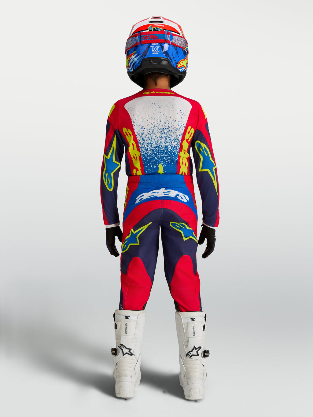 Alpinestars Conjunto Juventude Fluid Drag e Camisola 2027, conjunto de motocross em azul-marinho e vermelho, vista traseira no piloto.