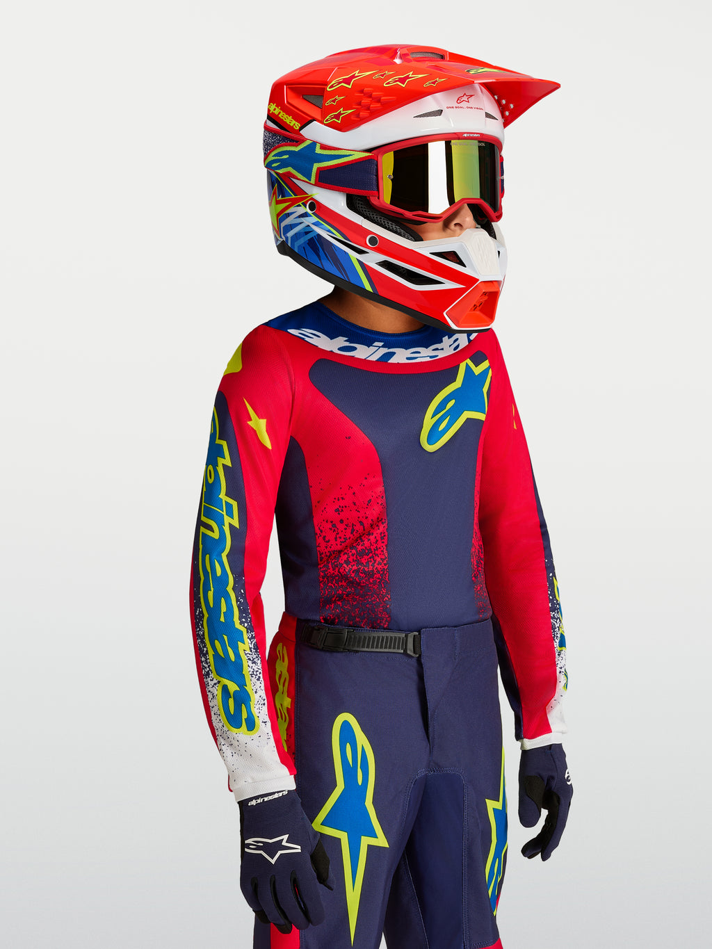 Camisola Alpinestars Fluid Drag Jovem, equipamento de motocross azul-marinho e vermelho com capacete de corrida a condizer.