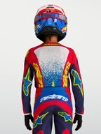 Alpinestars Camisola Fluid Drag Jovem 2027, camisola de motocross e todo-o-terreno para jovens, azul e vermelha, vista traseira de piloto com ajuste ergonómico.