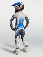 Alpinestars Fluid Drag Jovem, camisola e calças de motocross, cinzento e azul, vista traseira num jovem piloto.