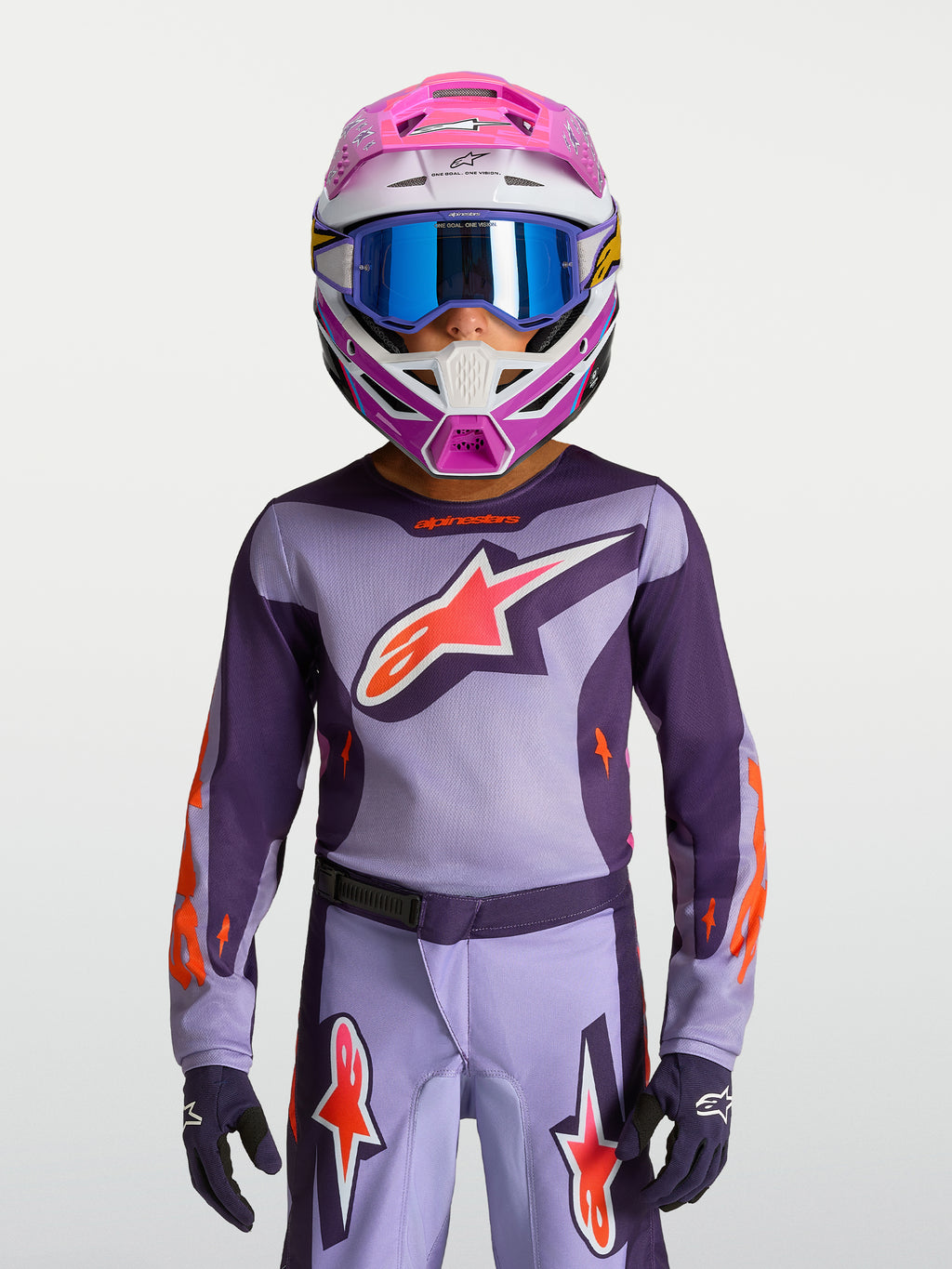 Camisola Alpinestars Fluid Hunt Jovem 2027, camisola de motocross roxa e rosa fluo, modelo com capacete e óculos.