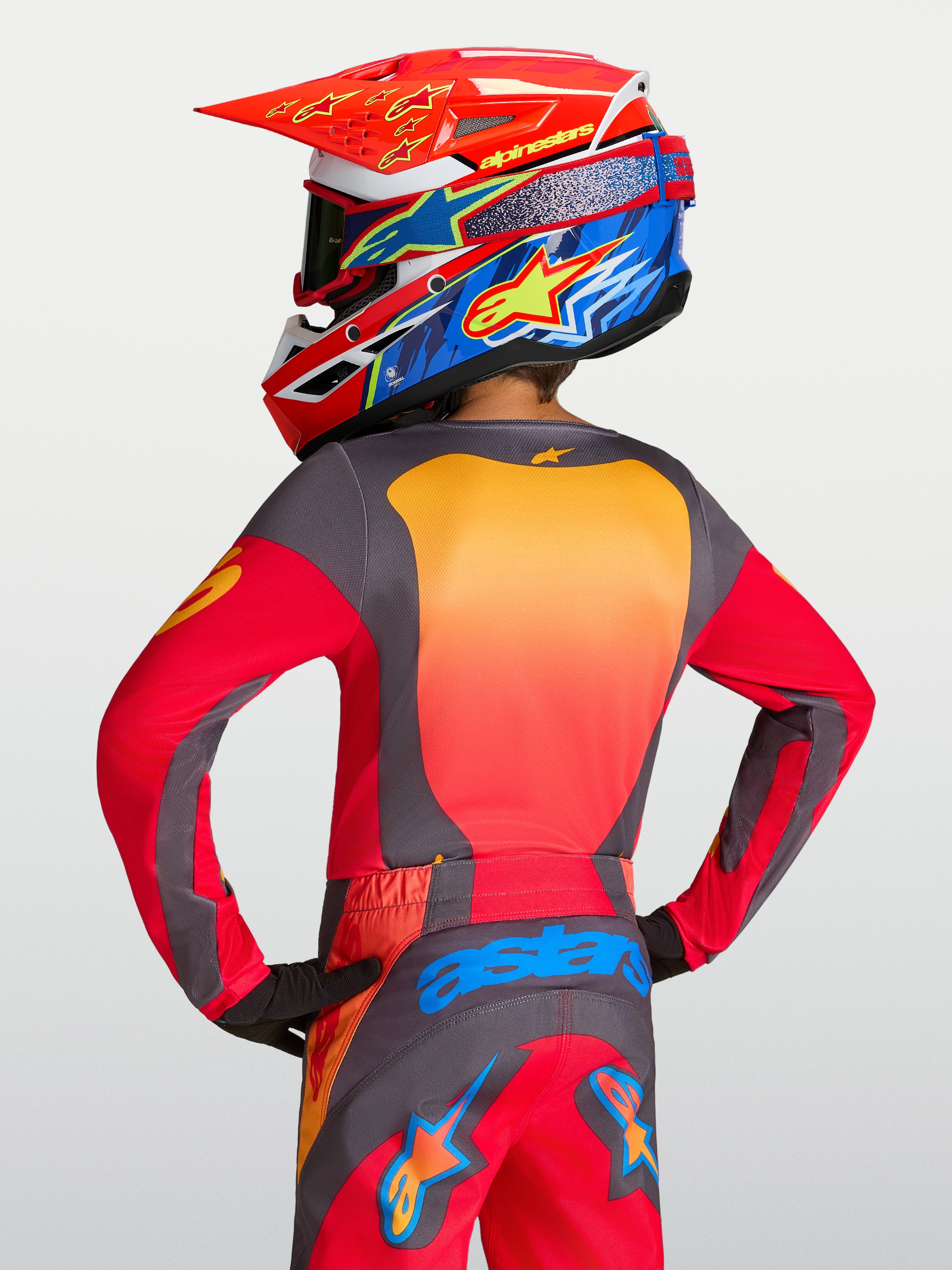 Alpinestars Camisola Fluid Hunt Juventude, camisola de motocross vermelha e cinzenta, vista traseira, ajuste atlético.