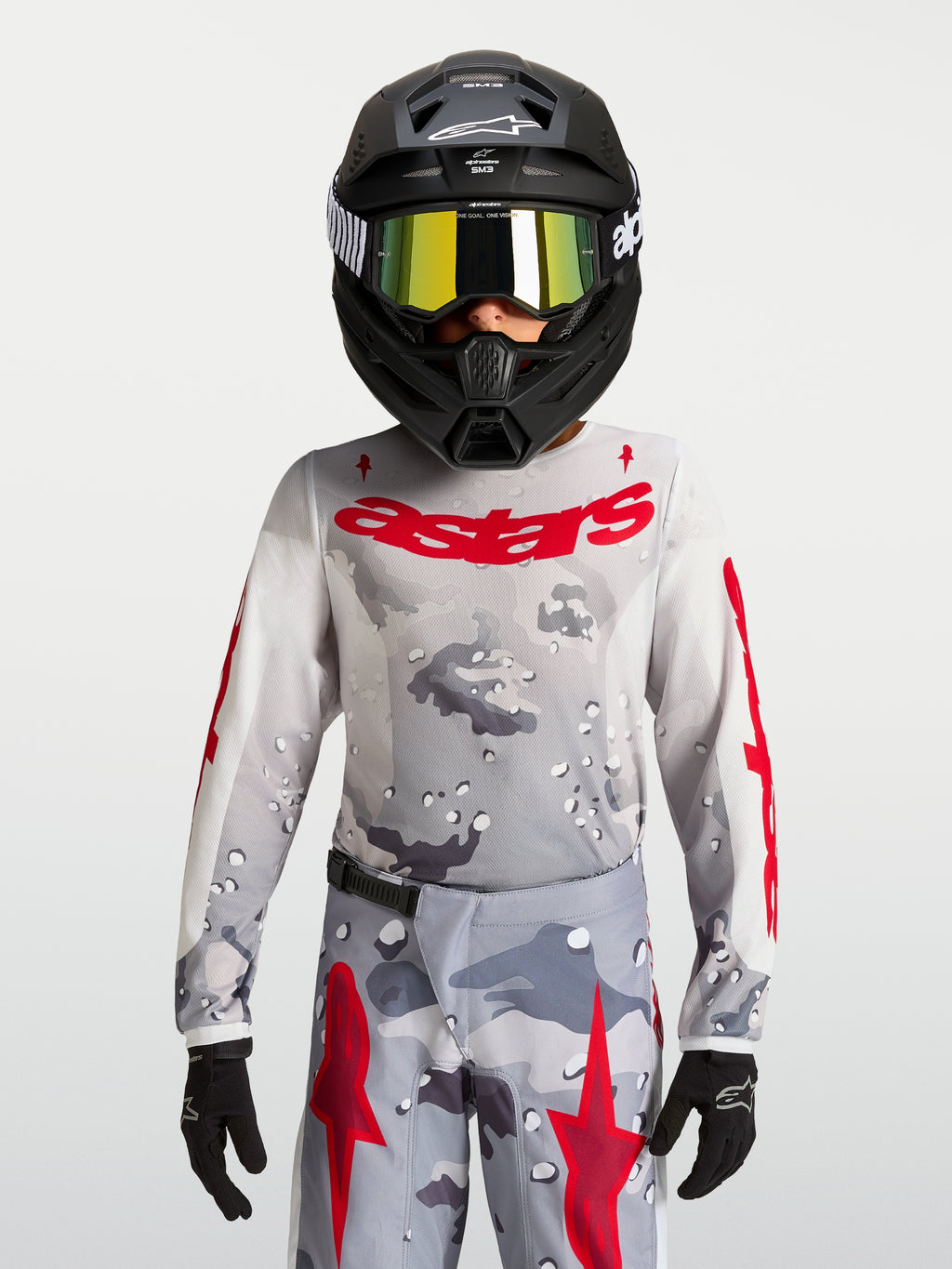 Alpinestars Camisola Fluid Lone Jovem 2027, camisola de motocross para jovens, cinzenta com padrão de camuflagem e logótipo em vermelho, construção em politecido leve e respirável.