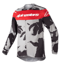 Alpinestars Youth 2023 Racer Tactical Jersey, camisola de motocross, camuflado cinzento e vermelho Mars, com uma faixa horizontal vermelha no peito e logótipo Alpinestars branco, padrão camuflado cinzento e preto, tecido leve que absorve a humidade para condução todo-o-terreno