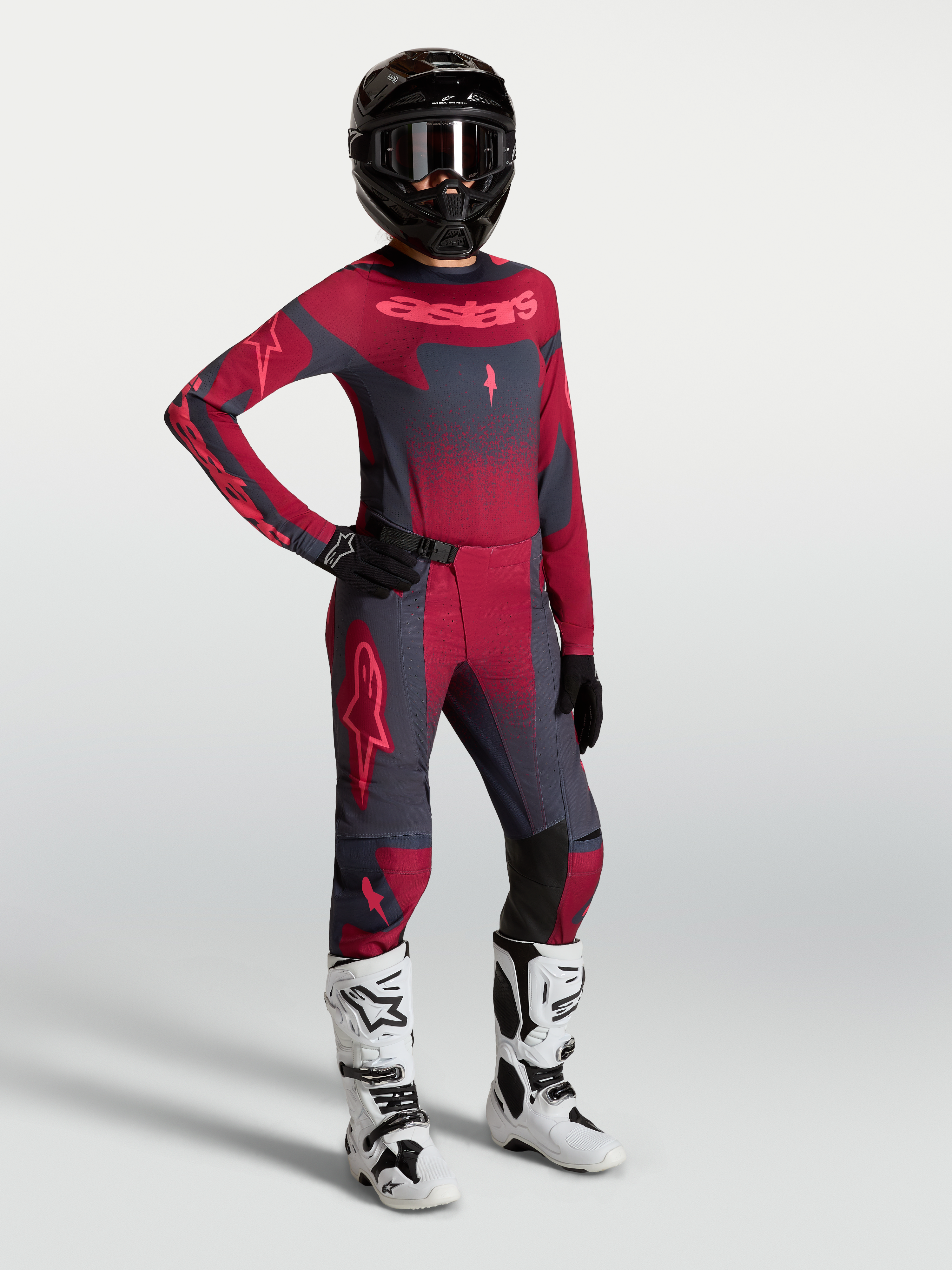 Alpinestars Stella Techstar Swan, camisola e calças de motocross para mulher, vermelho e cinzento escuro com botas brancas.