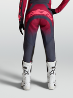 Alpinestars Calças Stella Techstar Swan, equipamento de motocross para mulher, vermelho e cinzento, vista traseira com botas de corrida brancas.