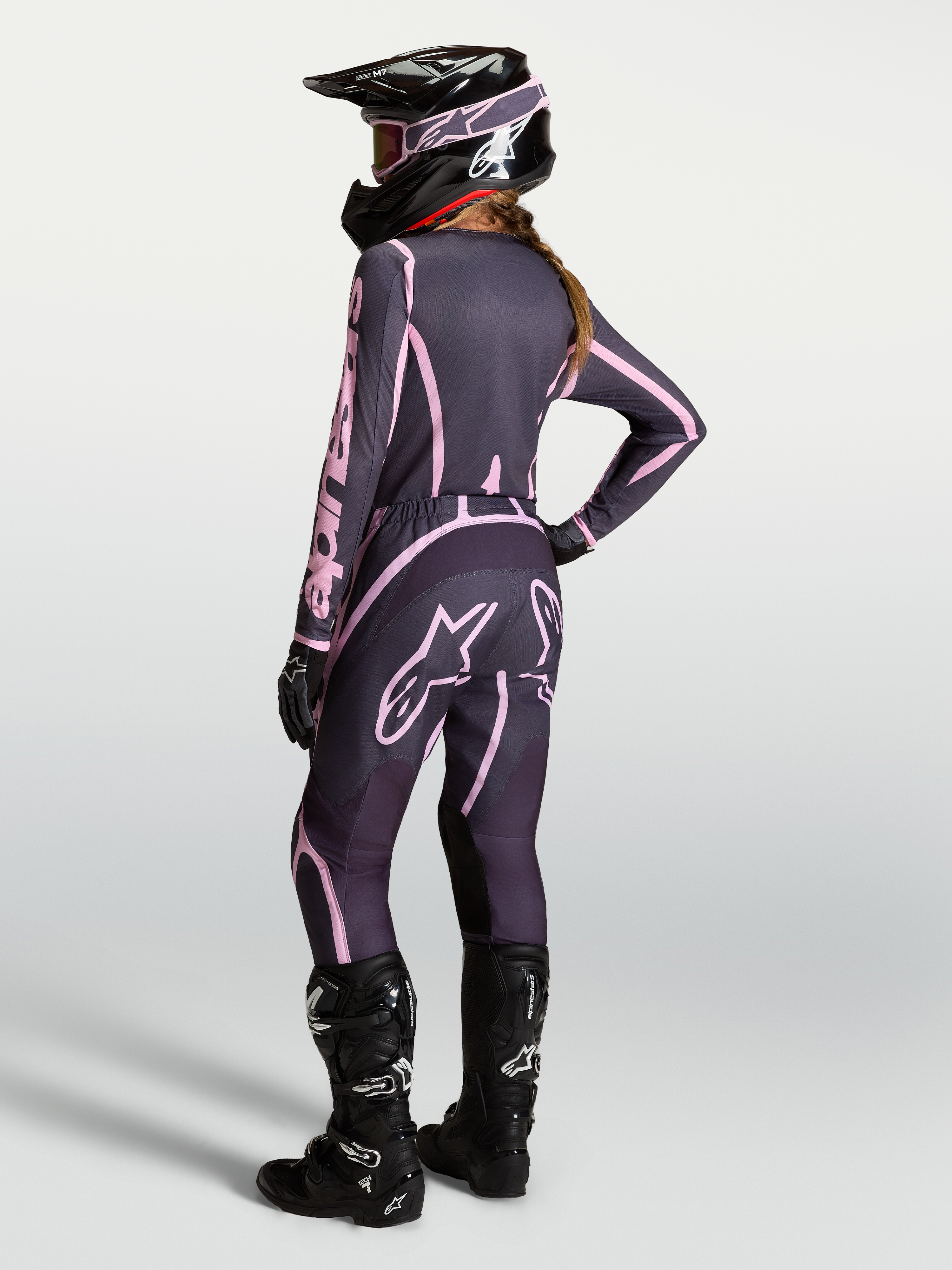 Alpinestars Stella Fluid Apex V2 camisola e conjunto, motocross para mulher, cinzento e rosa com botas pretas.