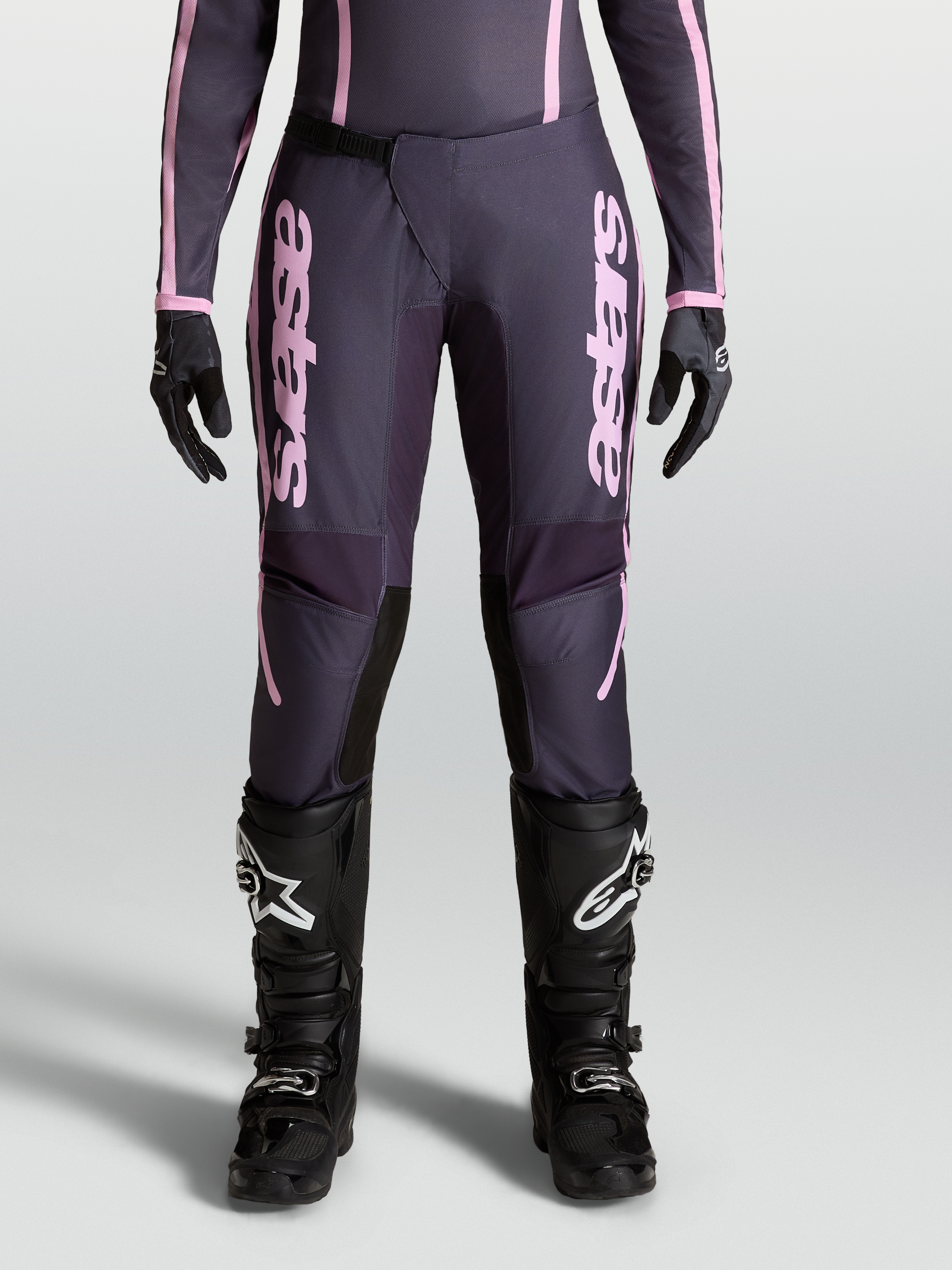 Alpinestars Stella Fluid Apex V2, calças de motocross para mulher, cinzentas e rosa, com perna pré-curvada e fecho de catraca frontal.