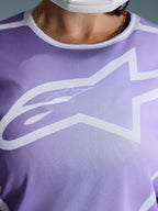 Alpinestars Stella Fluid Apex Jersey 2026, pormenor do peito, roxa com grafismos brancos, com um grande logótipo Astars branco em construção de malha de poliéster
