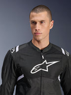 Casaco Alpinestars T-SPS Air V2, casaco de motociclismo têxtil, preto e branco, com grande logótipo branco no peito e painéis em malha, corte desportivo de performance usado por modelo masculino