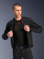 Alpinestars Troop-Air Pro Jacket, preto, casaco de ar blindado técnico premium com construção em malha, usado aberto sobre uma camada de base preta com um logótipo vermelho, combinado com calças de motociclismo em malha a condizer, estilo de condução urbano contemporâneo