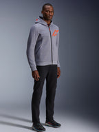 Alpinestars Chrome V2 Sport Hoodie, Gray Heather and Red Fluo, worn by a male model with black pants and dark athletic shoes, featuring a bright orange star logo on the chest and hood, casual urban riding apparel