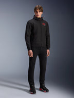 Alpinestars MM93 Radium Tech Hoodie, Urban Motorcycle Jacket, Black with Bright Red accents, worn by model with black pants and riding shoes, featuring red '93' chest logo and Marc Marquez branding on the sleeve, casual technical streetwear for urban riding