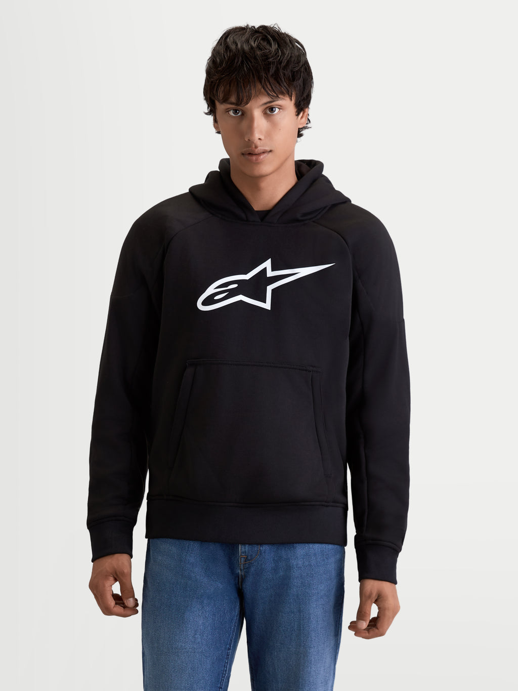 Alpinestars Ageless Hoodie, casaco com capuz de moto urbano para homem em preto com logótipo branco no peito, bolso canguru frontal e construção em tecido casual, vista frontal num modelo