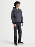 Alpinestars Ageless Hoodie, casaco com capuz de moto urbano para homem em cinzento melange de asfalto, vista frontal de um modelo a usar vestuário de condução casual com proteções CE nos ombros e cotovelos