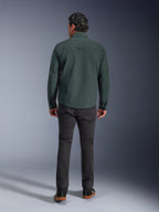 Alpinestars Bryon Water Resistant Overshirt in Dark Emerald, back view on model, paired with dark grey motorcycle pants and black riding shoes, showcasing a classic workwear-inspired design with a slightly longer back for riding coverage.