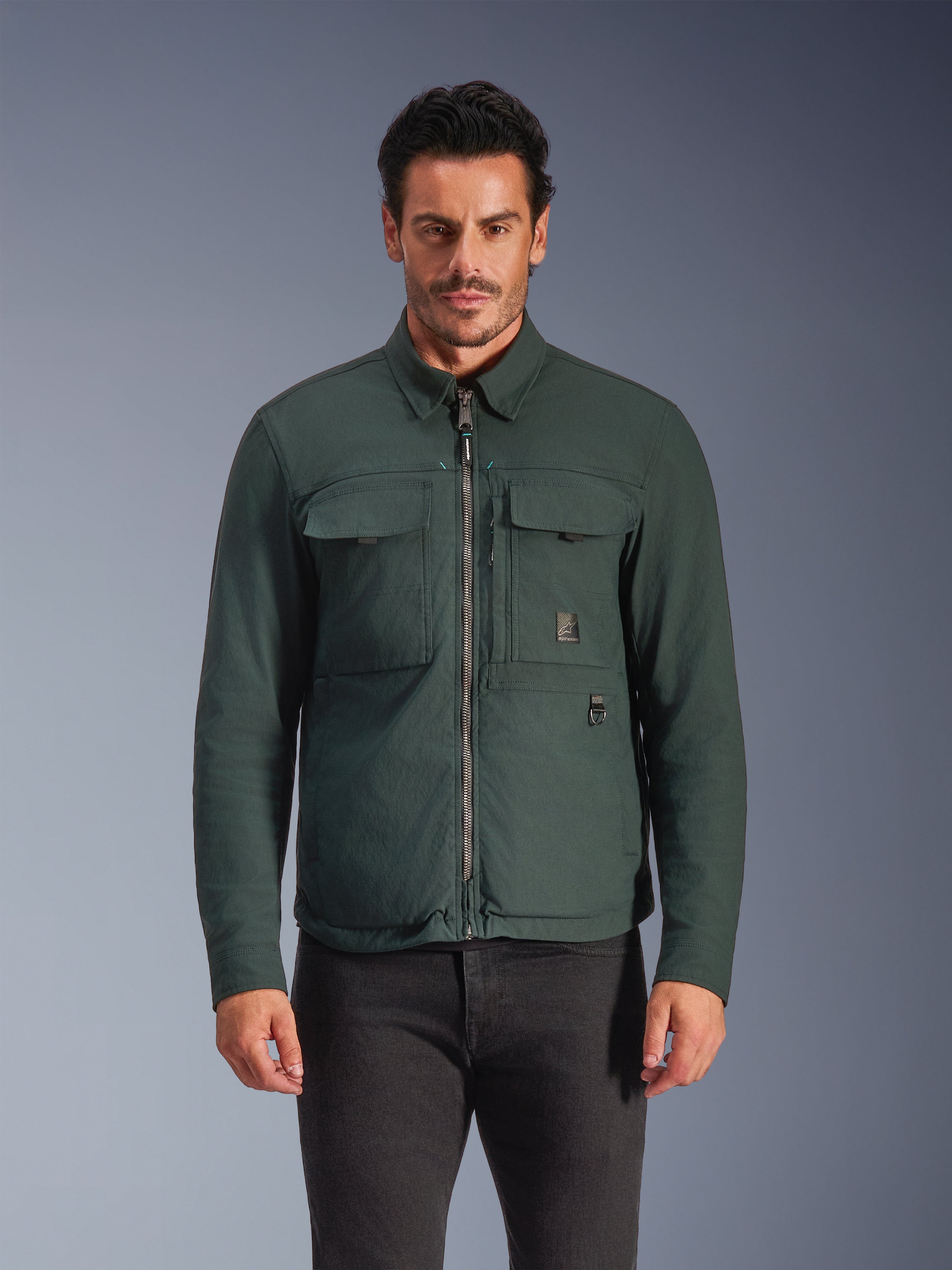 Alpinestars Bryon Water Resistant Overshirt, Dark Emerald, Men's Urban Riding Jacket, Male model wearing dark green overshirt with front zipper and large chest cargo pockets, water-resistant waxed canvas for motorcycle road riding