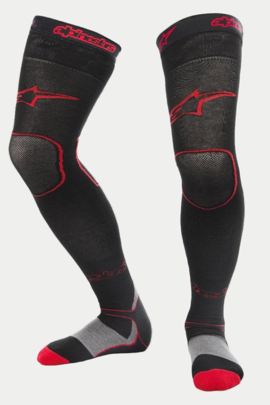 Alpinestars MX Long Tech Thick Socks, meias de motocross, pretas e vermelhas, com logótipos Alpinestars vermelhos na coxa e no punho, calcanhar cinzento e pormenores vermelhos na biqueira, comprimento até meio da coxa com zonas de malha especializadas, camada de base técnica para corridas de todo-o-terreno