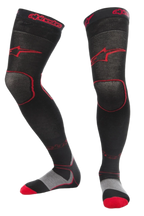 Meias Alpinestars MX Long Tech Thick, meias de motocross, pretas e vermelhas, comprimento até meio da coxa com logótipos vermelhos, detalhes na sola em cinzento e vermelho, tecido técnico concebido para corridas fora de estrada e botas de motocross