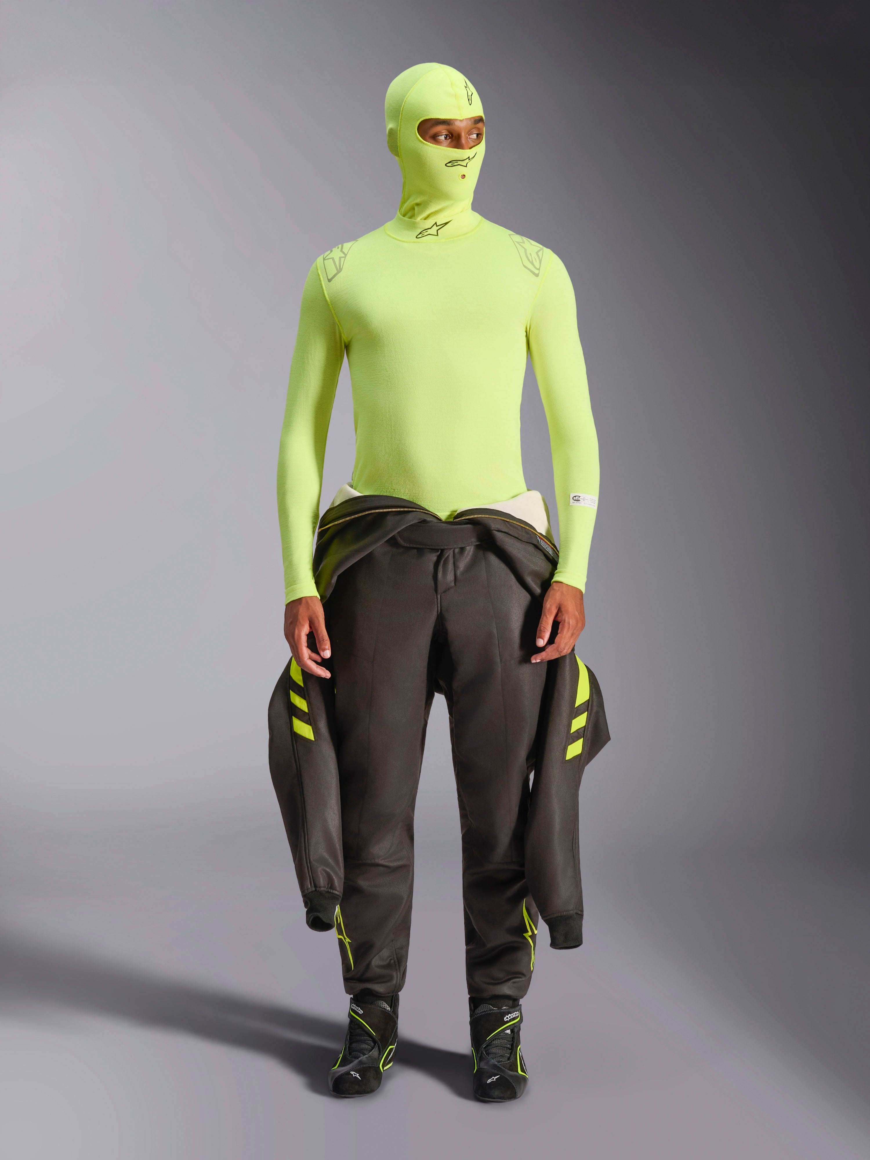 Alpinestars ZX Evo V3 Top de Manga Comprida, Amarelo Fluo, usado com balaclava a condizer e fato de corrida escuro atado à cintura, camada de base leve e resistente a chamas para automobilismo, com logótipos Alpinestars no colarinho e nos ombros