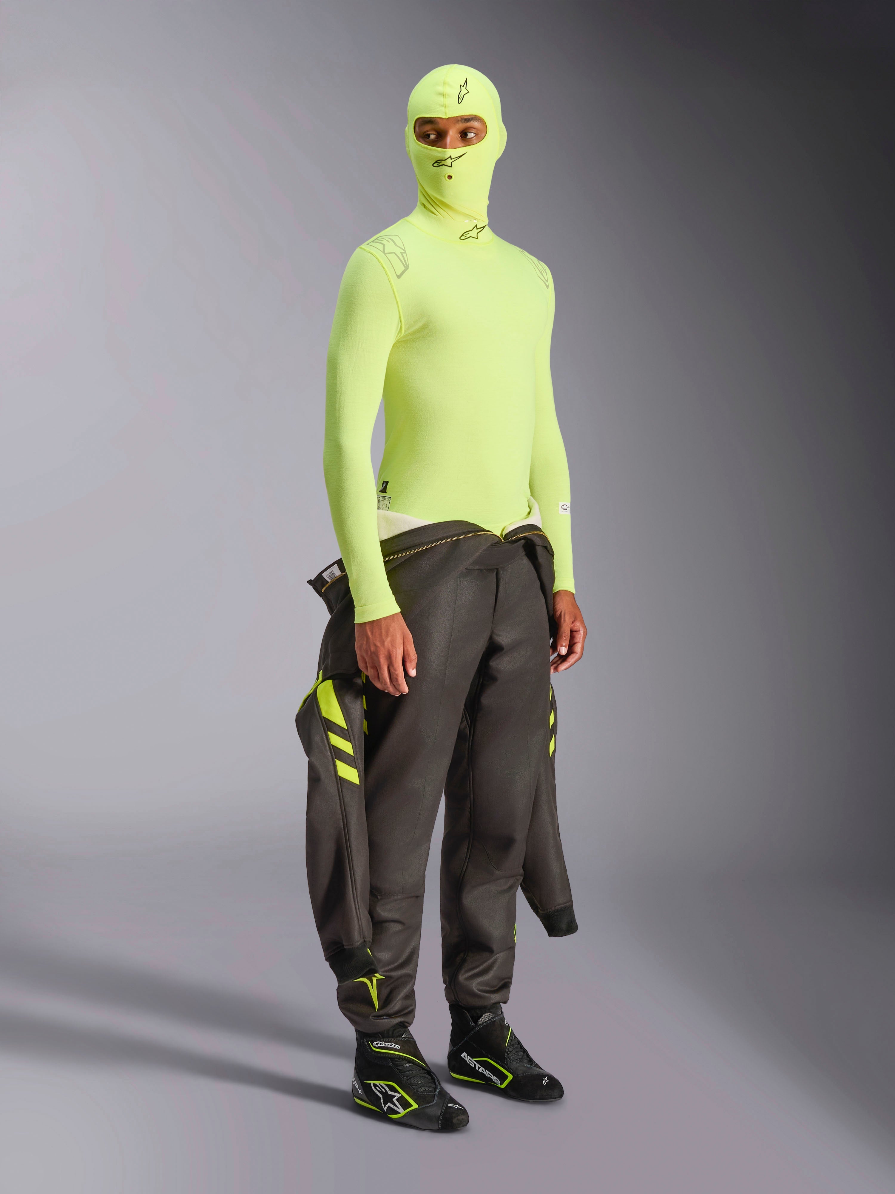 Alpinestars ZX Evo V3 Long Sleeve Top, Amarelo Fluo, camada de base para automobilismo usada com balaclava a condizer e fato de competição escuro atado à cintura, roupa interior resistente ao fogo em amarelo néon de alta visibilidade