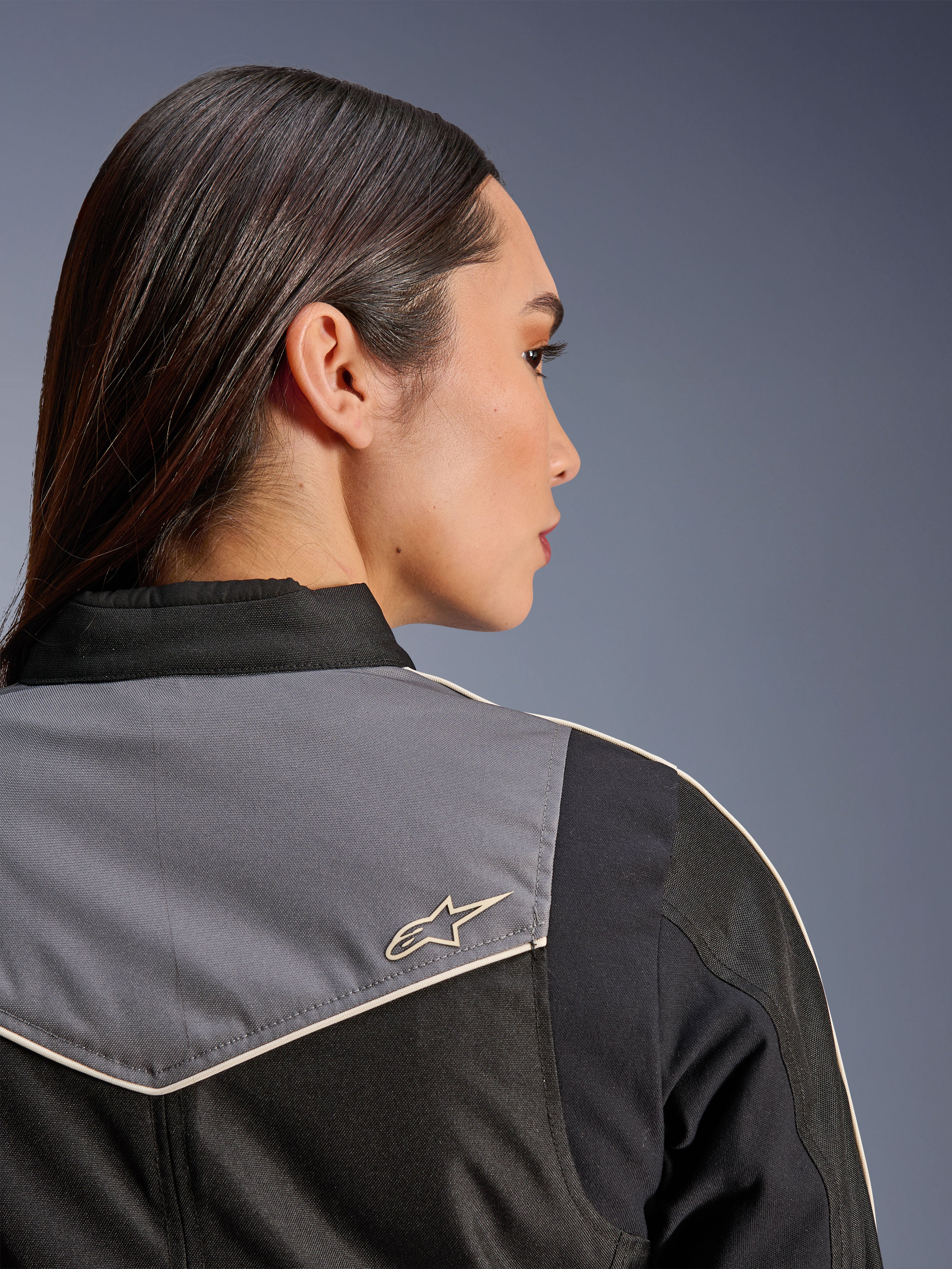 Alpinestars Stella T-Dyno WR Jacket, casaco de motociclismo feminino, preto, cinzento escuro e ecru, vista traseira aproximada do ombro e da pala com painel cinzento e logótipo de estrela ecru, equipamento de condução de inspiração vintage
