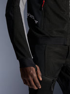 Alpinestars Troop-Air Pro Jacket, casaco de ar blindado técnico premium, preto, cinzento ash e vermelho brilhante, com construção em malha tecnológica 2D para ventilação, painéis das mangas em cinzento ash, detalhe de fecho vermelho e punhos com abertura para o polegar integrada, usado com calças a condizer