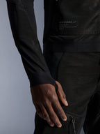Alpinestars Troop-Air Jacket, preto, grande plano que mostra a construção em malha técnica, emblema da marca com texto técnico e manga com abertura integrada para o polegar, casaco de motociclismo urbano de verão com design de elevado fluxo de ar