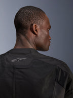 Casaco Alpinestars C-1 Air, casaco de motociclismo preto, grande plano das costas mostrando painéis de malha técnica respirável e logótipo Alpinestars refletor na gola, equipamento de condução urbana