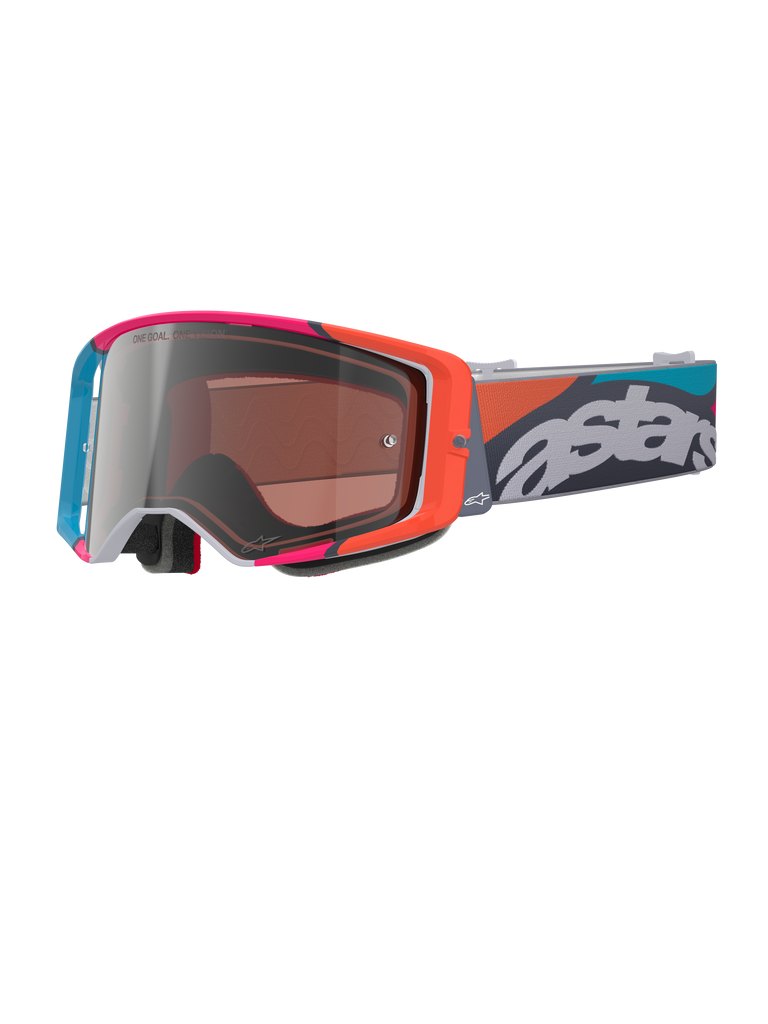Óculos Alpinestars Supertech Stream, armação cinzenta com realces vibrantes em vermelho e azul, lente prateada Multi Mirror Silver, acolchoamento de espuma espessa, fita ajustável com a marca 'astars' em destaque a branco e padrões geométricos coloridos, proteção ocular profissional para motocross