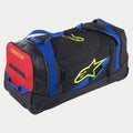 Bolsa de Viagem Alpinestars Komodo, saco de equipamento com rodas, preto, azul, vermelho e amarelo fluo, com alças de tecido azul, painel lateral vermelho e logótipos em amarelo fluorescente, construção durável com rodas para transporte de equipamento de motocross e competição