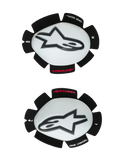 Alpinestars GP Tech Knee Sliders, deslizadores de joelho para motociclismo, brancos e pretos, conjunto de deslizadores esquerdo e direito com capas de plástico branco e logótipos Astar pretos, base de velcro com a inscrição 'ONE GOAL ONE VISION', equipamento de corrida de alta performance