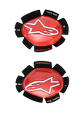 Alpinestars GP Tech Knee Sliders, vermelhos e brancos, protetores de joelho para competição de motociclismo, logótipo de estrela branca em plástico vermelho brilhante, texto 'ONE GOAL. ONE VISION.' em suporte de velcro preto em forma de pétala, par esquerdo e direito para uso em pista