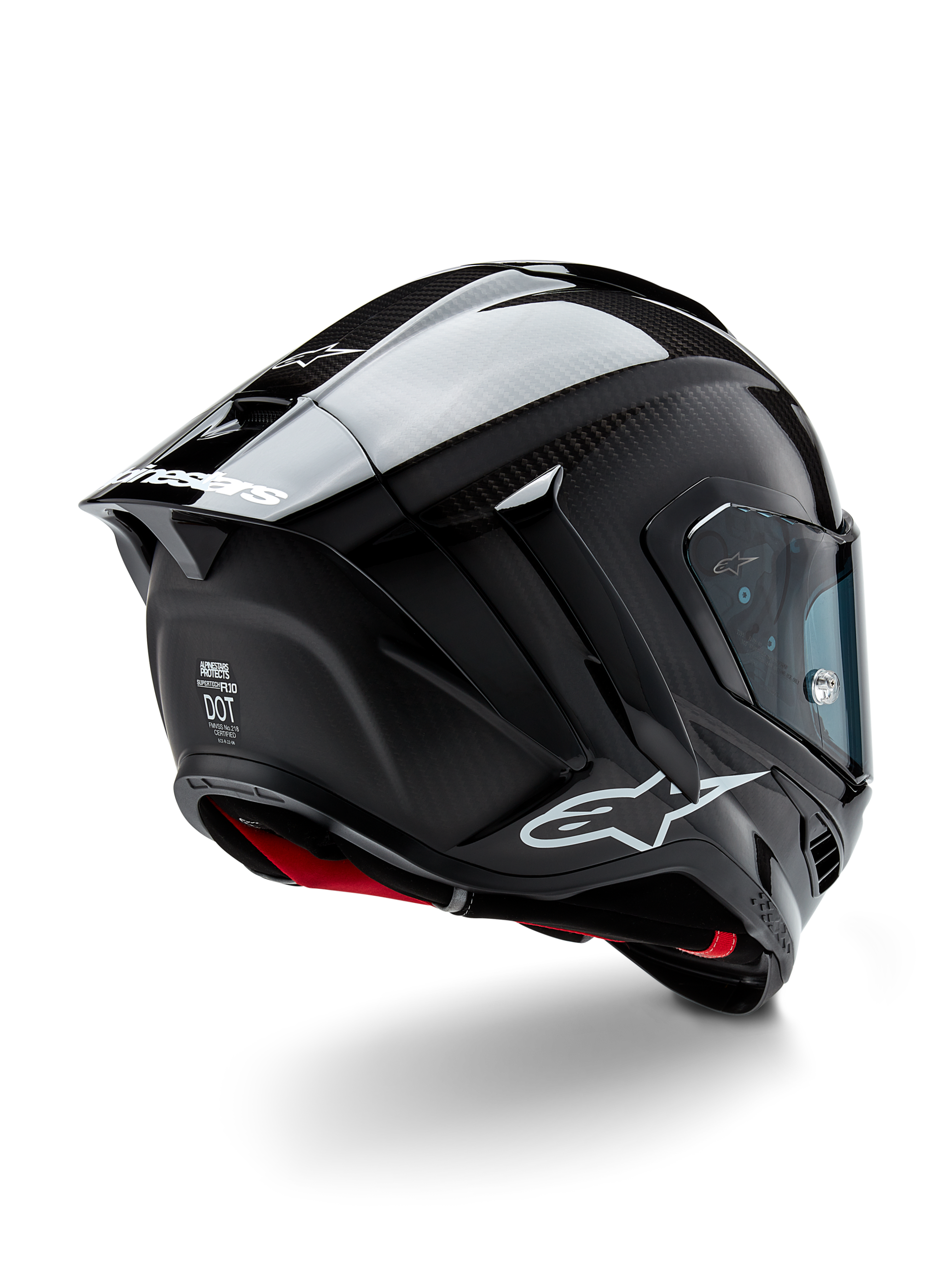 Capacete Alpinestars Supertech R10 Solid, capacete de corrida para motociclismo, acabamento em carbono preto mate e brilhante, vista traseira de três quartos mostrando o casco em fibra de carbono, spoiler aerodinâmico e logótipo Alpinestars
