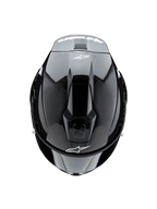 Capacete Alpinestars Supertech R10 Solid, vista superior, em carbono preto mate e brilhante, apresentando textura de fibra de carbono nas laterais, secção central brilhante, entradas de ar aerodinâmicas e logótipo Alpinestars branco na frente e na traseira
