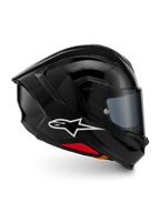 Capacete Alpinestars S-R7 Solid, capacete integral de motociclismo, preto brilhante, vista de perfil com logótipo A-star branco, casco aerodinâmico com spoiler integrado e detalhes vermelhos na base, concebido para competição e performance desportiva.