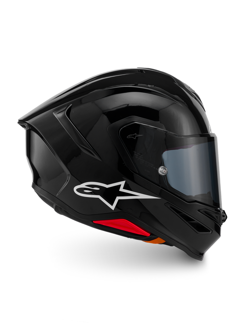 Capacete Alpinestars S-R7 Solid, capacete integral de motociclismo, preto brilhante, vista de perfil com logótipo A-star branco, casco aerodinâmico com spoiler integrado e detalhes vermelhos na base, concebido para competição e performance desportiva.