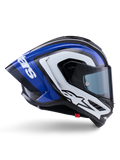 Capacete Alpinestars Supertech R10 Arius, capacete de corrida integral, acabamento brilhante em preto, branco e azul, vista lateral aerodinâmica mostrando o casco em fibra de carbono e spoiler traseiro grande com o logótipo da Alpinestars, equipamento de proteção profissional para motociclismo