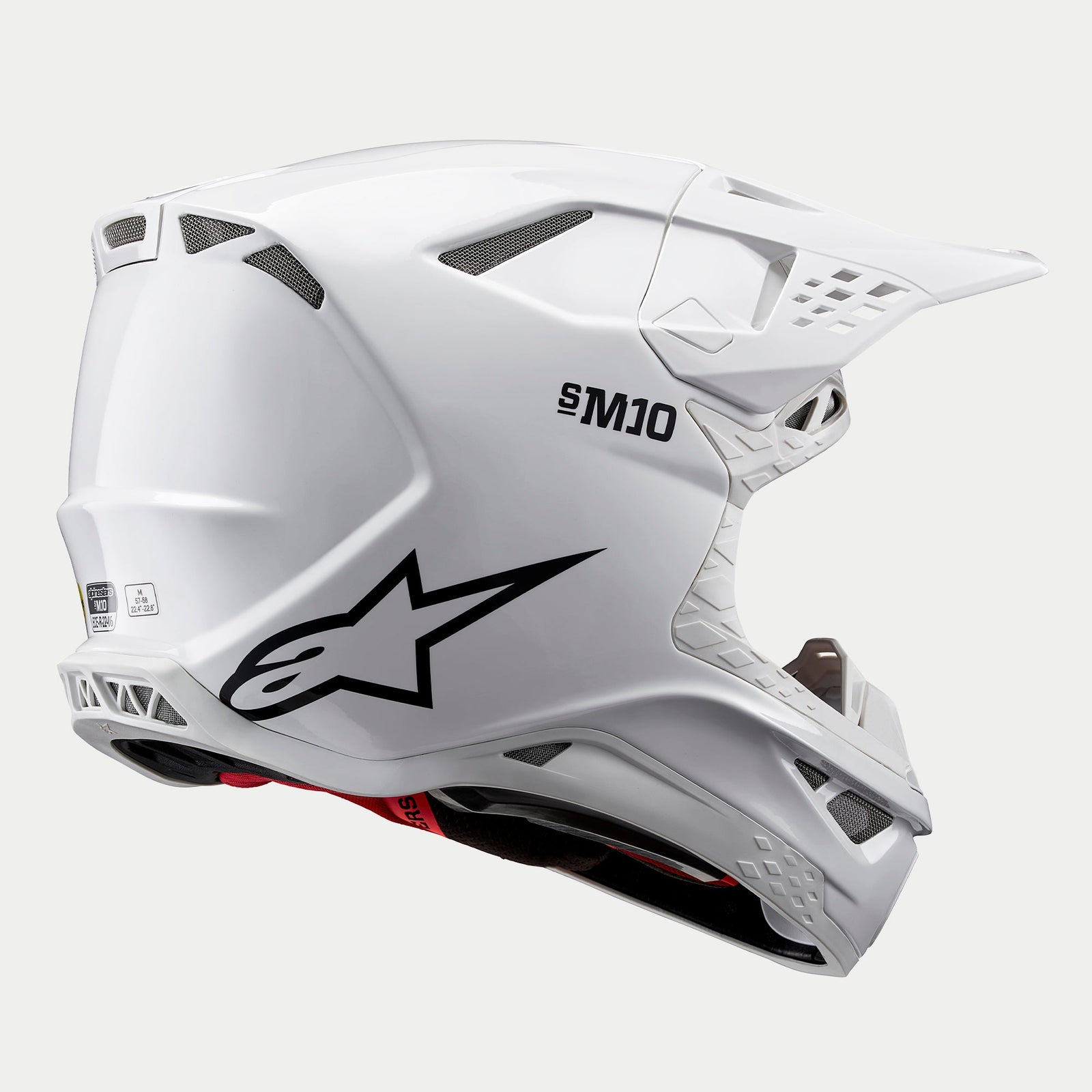 Capacete Alpinestars Supertech M10 Solid, capacete de motocross, branco brilhante, vista traseira em três quartos exibindo a calota aerodinâmica, logótipo da estrela preto e marca S-M10, múltiplas aberturas de ventilação para corridas de todo-o-terreno